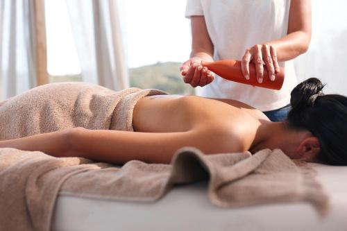 a woman laying on a bed getting her hair brushed at Sigma Residences Boutique Hotel in Exámbela