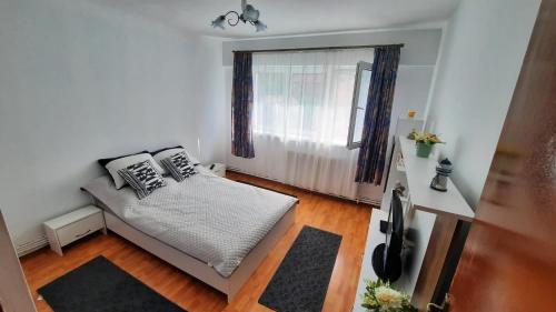 Habitación pequeña con cama y ventana en Bubu Apartament, en Petroşani