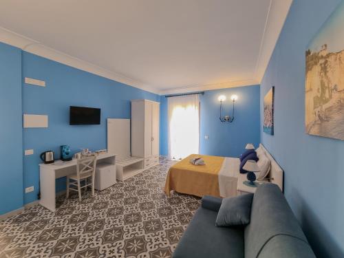 a blue room with a bed and a couch at La Bifora e il granaio in Sciacca