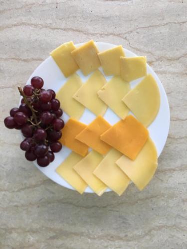 a plate of cheese and grapes on a table at Maison 7 in El Obour