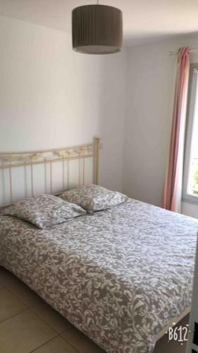 une chambre avec un lit et une fenêtre dans l'établissement Bastide au pieds des alpilles St remy de Provence piscine partagée dans résidence, à Saint-Rémy-de-Provence