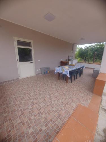 an empty room with a table and benches in it at VILLA L&M in Floridia