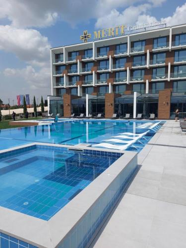 a large swimming pool in front of a hotel at Merit Grand Mosta Spa Hotel & Casino in Svilengrad