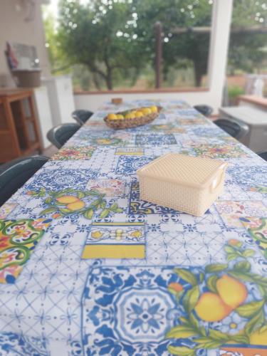 a table with a table cloth with a box on it at VILLA L&M in Floridia