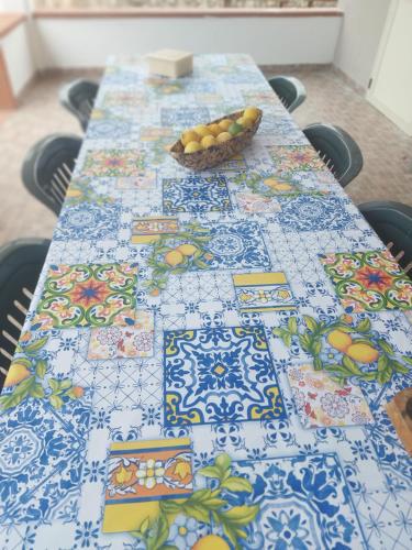 a table with a table cloth with a bowl of fruit on it at VILLA L&M in Floridia