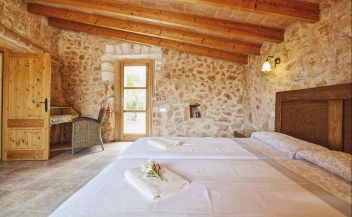 sypialnia z 2 łóżkami w pokoju z kamiennymi ścianami w obiekcie Can Mascaro w Manacorze