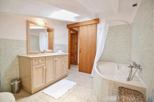 łazienka z wanną, umywalką i lustrem w obiekcie Can Mascaro w Manacorze
