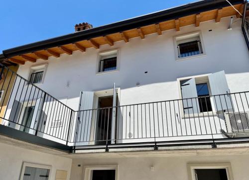 a white building with a balcony with a fence at Residenza Orchidee in Costermano