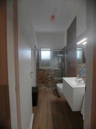a bathroom with a toilet and a sink and a shower at VILLA L&M in Floridia