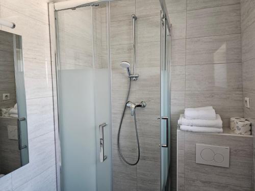 um chuveiro com uma porta de vidro na casa de banho em Hôtel Bellevue et du Chariot d'Or em Paris