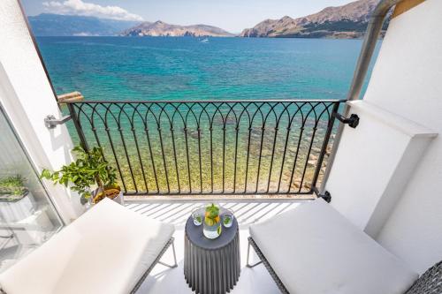 a balcony with a table and chairs and the ocean at Seafront Baska Apartment in Baška