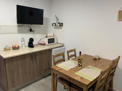 cocina con mesa de madera y microondas en Casita en el Tajo, en Setenil