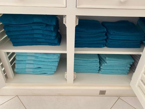 a closet with blue towels in it at Vila Mare - Praia de Chaves frontline in Cabeçadas