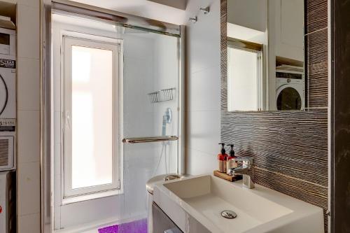 a white bathroom with a sink and a mirror at Exquisite Seafront Apart in Spinola Bay St Julians in Paceville