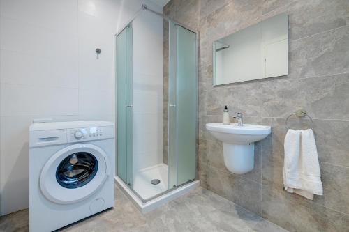 a bathroom with a washing machine and a sink at Luxury Maisonette in a Tranquil and Central Area in St Julian's