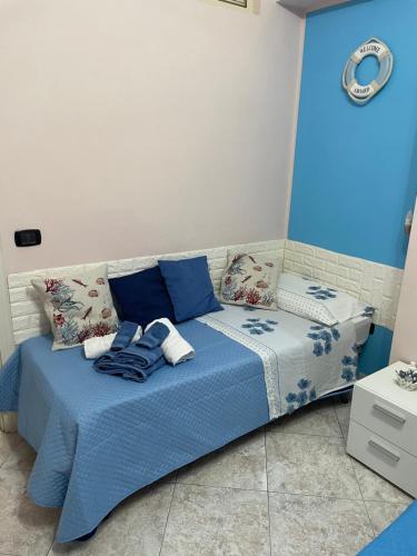 a bedroom with a blue bed with towels on it at Da Santina in Scilla