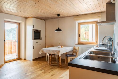 a kitchen with a table and a kitchen with a sink at Haflingerhof in San Genesio Atesino