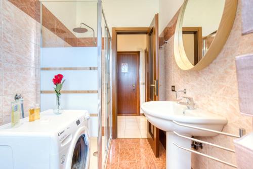 bagno con lavatrice e lavandino di CaseOspitali - Casa Graziella a 5 min dal San Raffaele a Milano