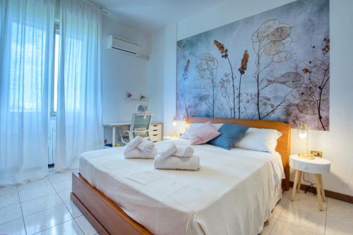 una camera da letto con un grande letto con asciugamani di CaseOspitali - Casa Graziella a 5 min dal San Raffaele a Milano