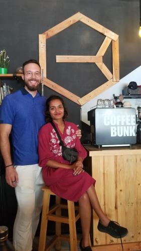 a man and a woman sitting on a stool at CoffeeBunk Hostel in Tangerang