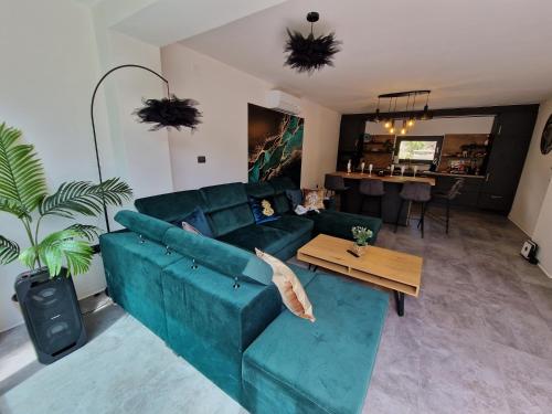 ein Wohnzimmer mit einem blauen Sofa und einem Tisch in der Unterkunft Villa Porta Krk in Krk