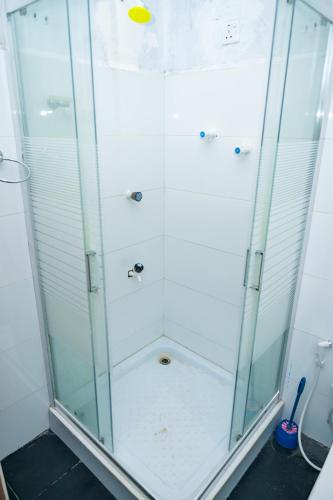 a shower with glass doors in a bathroom at Thisha Hotel & Restaurant in Jaffna