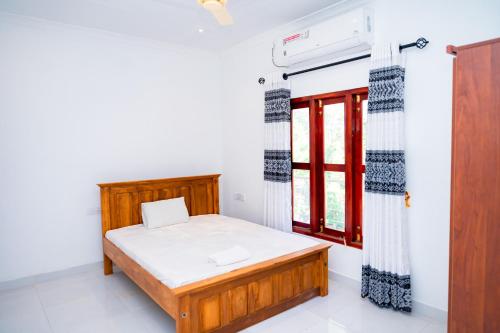 a bedroom with a bed and a window at Thisha Hotel in Jaffna