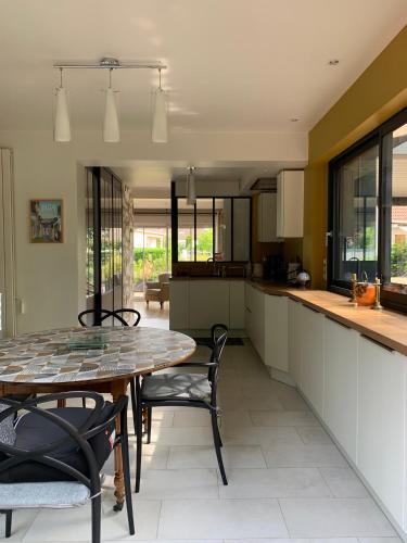 une cuisine et une salle à manger avec une table et des chaises dans l'établissement La Gitane, à Saint-Valery-sur-Somme