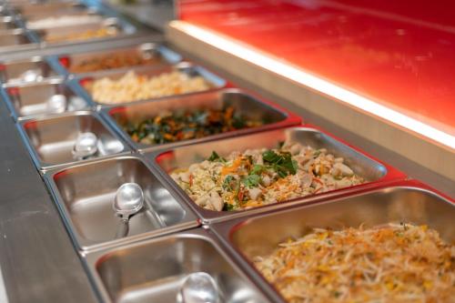 a bunch of trays of food in a buffet at Blue Hippo & Red Crocodile Hotel in Bangna