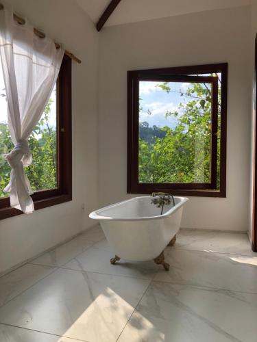 e bagno con finestra e vasca. di Guest House Fazenda do Francês & Culinária Francesa a Cachoeiras de Macacu