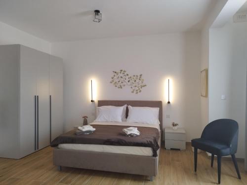 a bedroom with a bed and a blue chair at Coral Reef Apartments in St. Paul's Bay