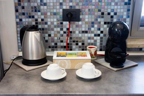a counter top with a coffee maker and plates on it at Pozzillo appartament -near the cathedral in Monreale