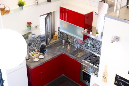 an overhead view of a kitchen with red cabinets at Pozzillo appartament -near the cathedral in Monreale