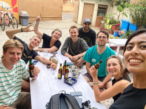 een groep mensen die rond een tafel zitten met flessen wijn bij Nextdoor Patan in Pātan