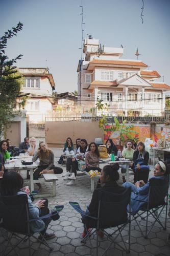 a group of people sitting in chairs on a patio at Nextdoor Patan in Pātan