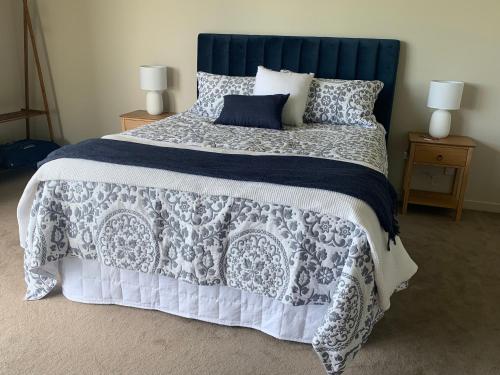 1 dormitorio con 1 cama grande y cabecero azul en Brancott Ridge, en Renwick