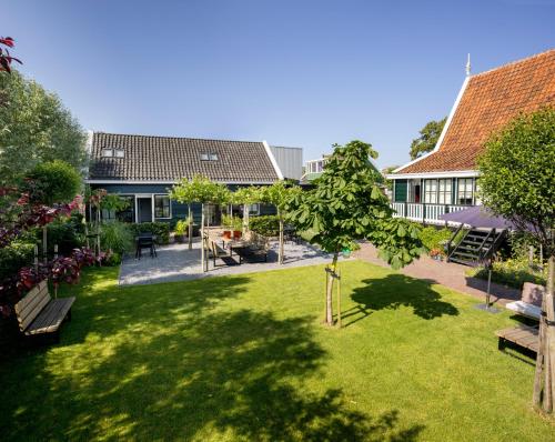 einen Garten mit Bänken und Tischen und ein Gebäude in der Unterkunft Saenliefde in Wormer