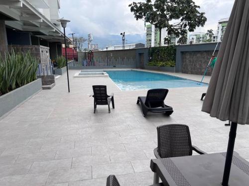 eine Terrasse mit Stühlen und einem Pool in der Unterkunft Modern pent house apartment, close to everything in Dosquebradas