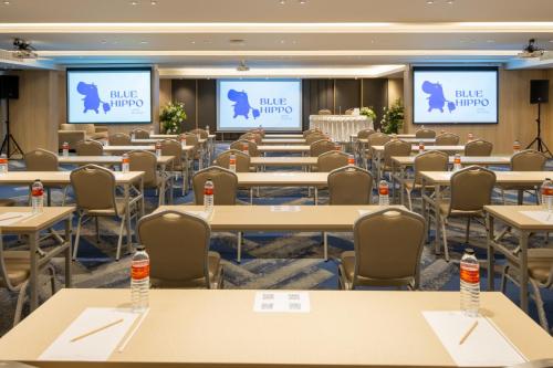 a conference room with tables and chairs and screens at Blue Hippo & Red Crocodile Hotel in Bangna