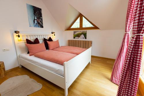 - une chambre avec un lit doté d'oreillers rouges dans l'établissement Alpine Base Kranjska Gora, à Kranjska Gora