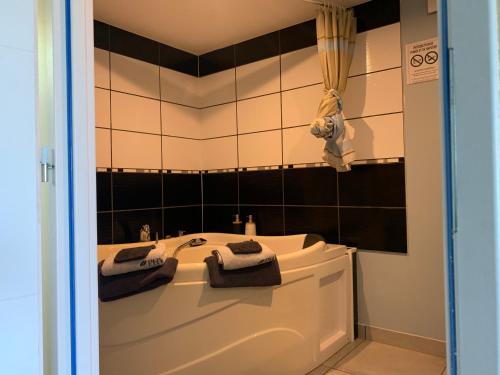 een badkamer met een bad en 2 handdoeken bij Dépendance chaleureuse et calme in Champagneux