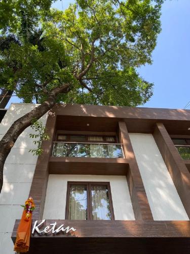 a building with a tree in front of it at Hotel Ketan in Pune