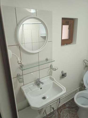 a bathroom with a sink and a mirror and a toilet at Camera con bagno in Ploieşti