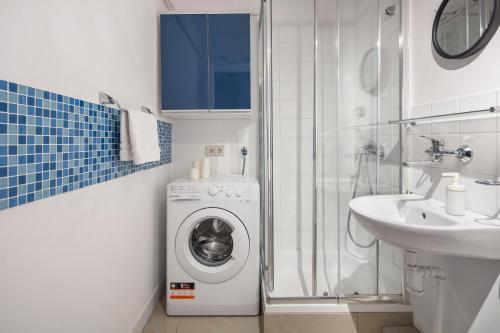 a bathroom with a washing machine and a sink at Sleepy3city with Sea View II in Gdynia