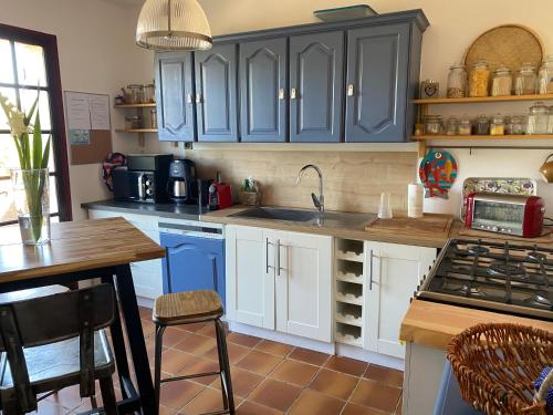 een keuken met blauwe kasten en een wastafel bij Maison provençale in Six-Fours-les-Plages