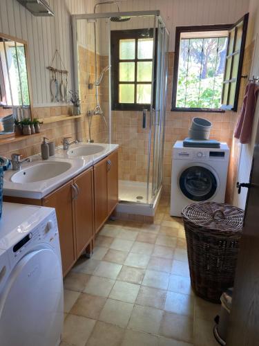 een badkamer met een wastafel en een wasmachine bij Maison provençale in Six-Fours-les-Plages
