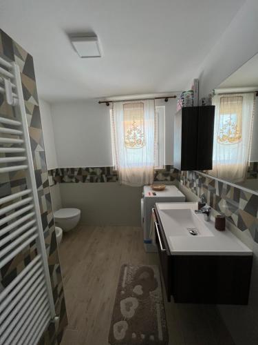 un piccolo bagno con due lavandini e servizi igienici di Il casale del Nonno Armando a Torrevecchia Teatina