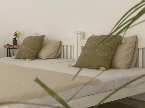 a bedroom with two beds with pillows and a plant at Moksha Sigiriya in Sigiriya