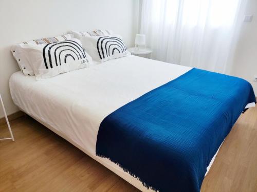Una gran cama blanca con una manta azul. en Apartment near Expo of Lisboa, en Lisboa
