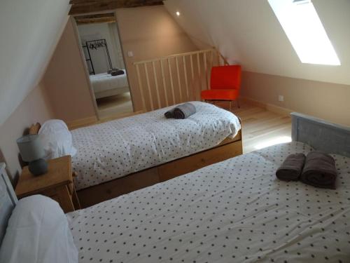 une chambre avec deux lits et une chaise rouge dans l'établissement Domaine avec piscine à Milhac dans le Lot 4 étoiles 2 gîtes, à Milhac